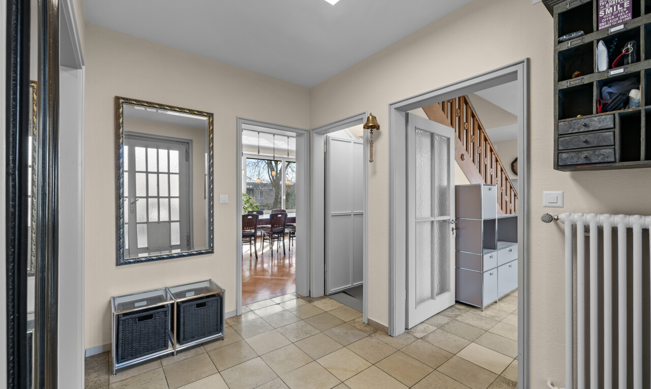 hall with radiator and light tile patterned floors