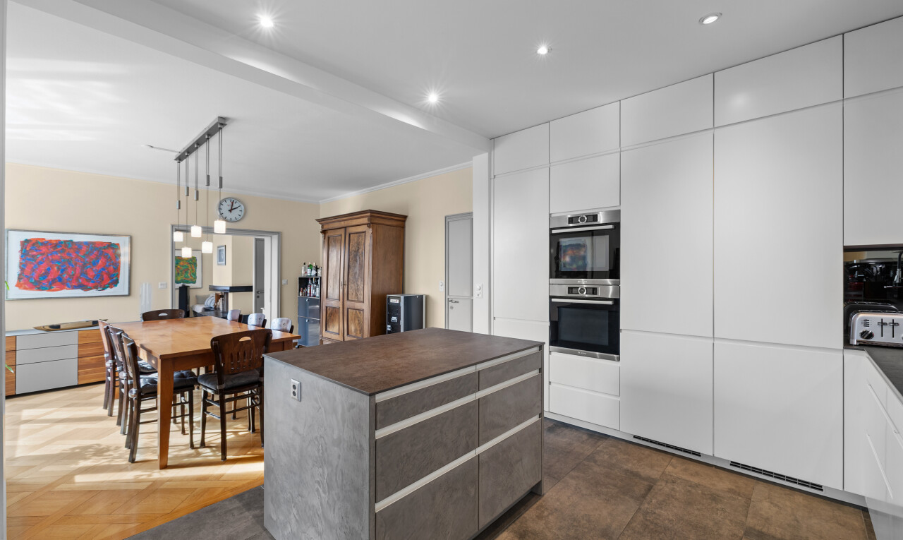 kitchen featuring dark countertops, modern cabinets, white cabinetry, a kitchen island, and double oven