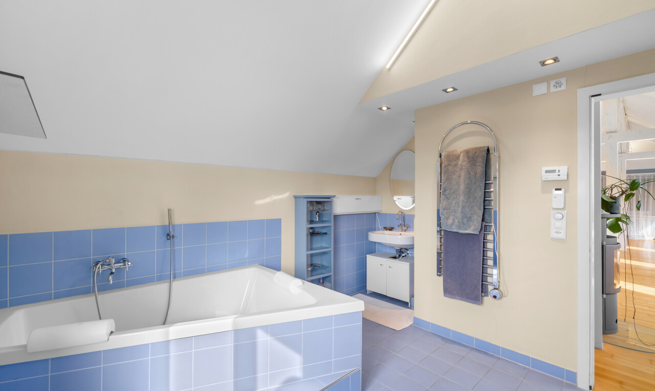 full bathroom with dark tile patterned flooring, vanity, vaulted ceiling, and a bath