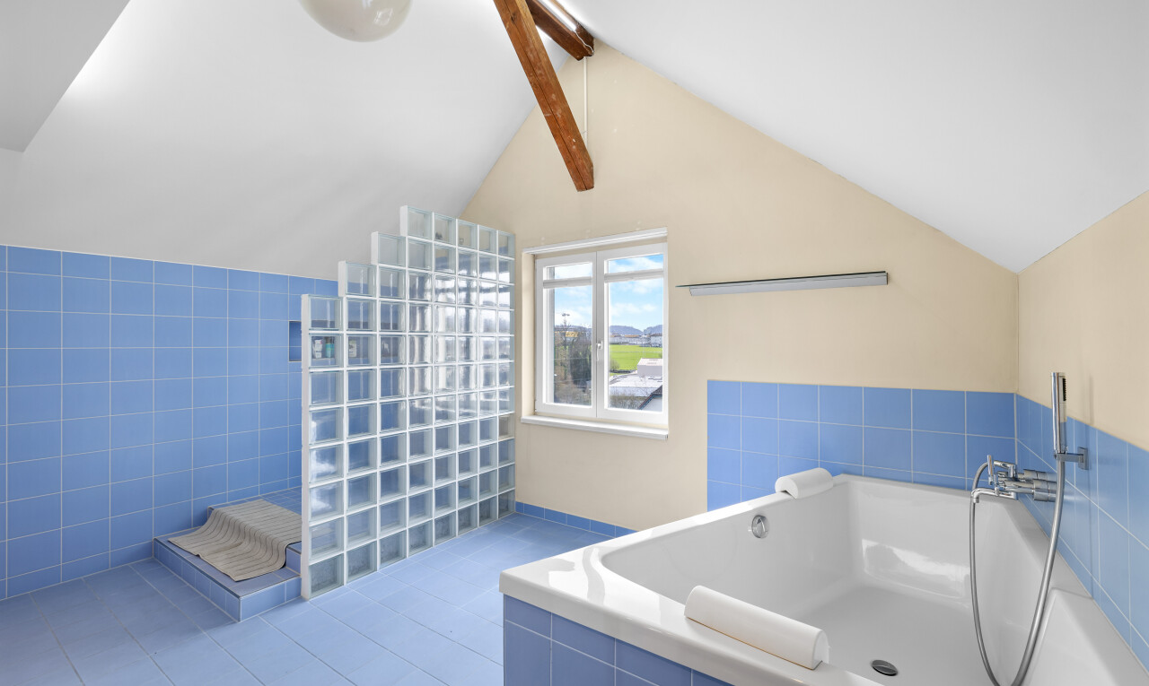bathroom with beamed ceiling, a bath, tile walls, and a walk in shower