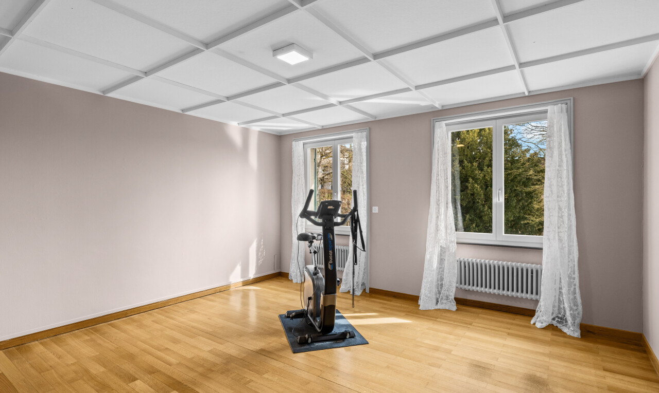 gym avec coffered ceiling, plafond à caissons, radiateur, wood finish floor, et sol en finition bois