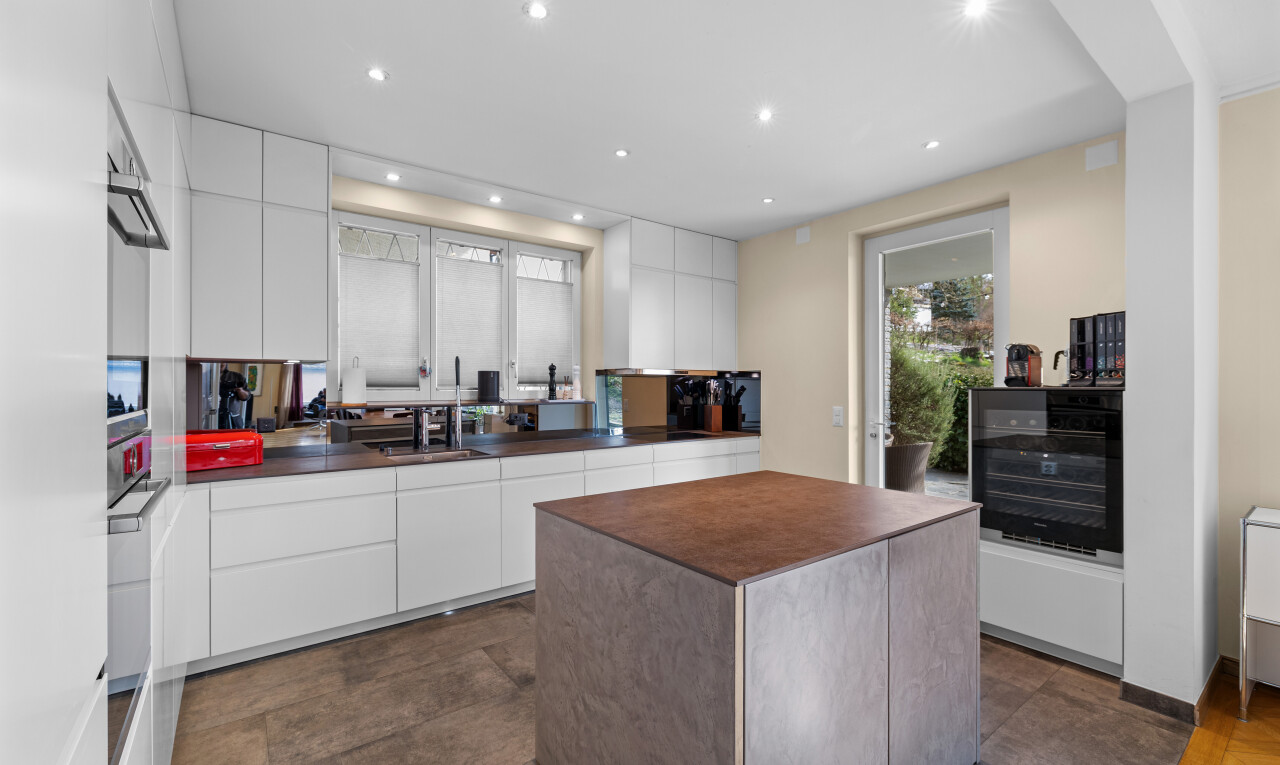 cuisine avec dark floor, flat panel cabinets, armoires à panneau plat, inside property, et drywall