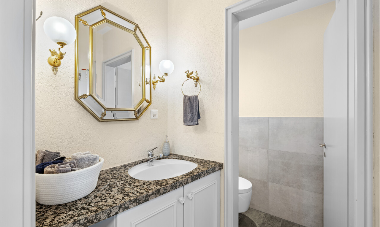 salle de bains avec miroir, lavabo (ou coiffeuse selon le contexte), inside property, toilette, et évier