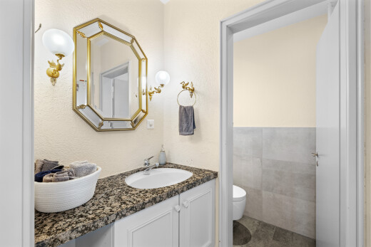 salle de bains avec miroir, lavabo (ou coiffeuse selon le contexte), inside property, toilette, et évier