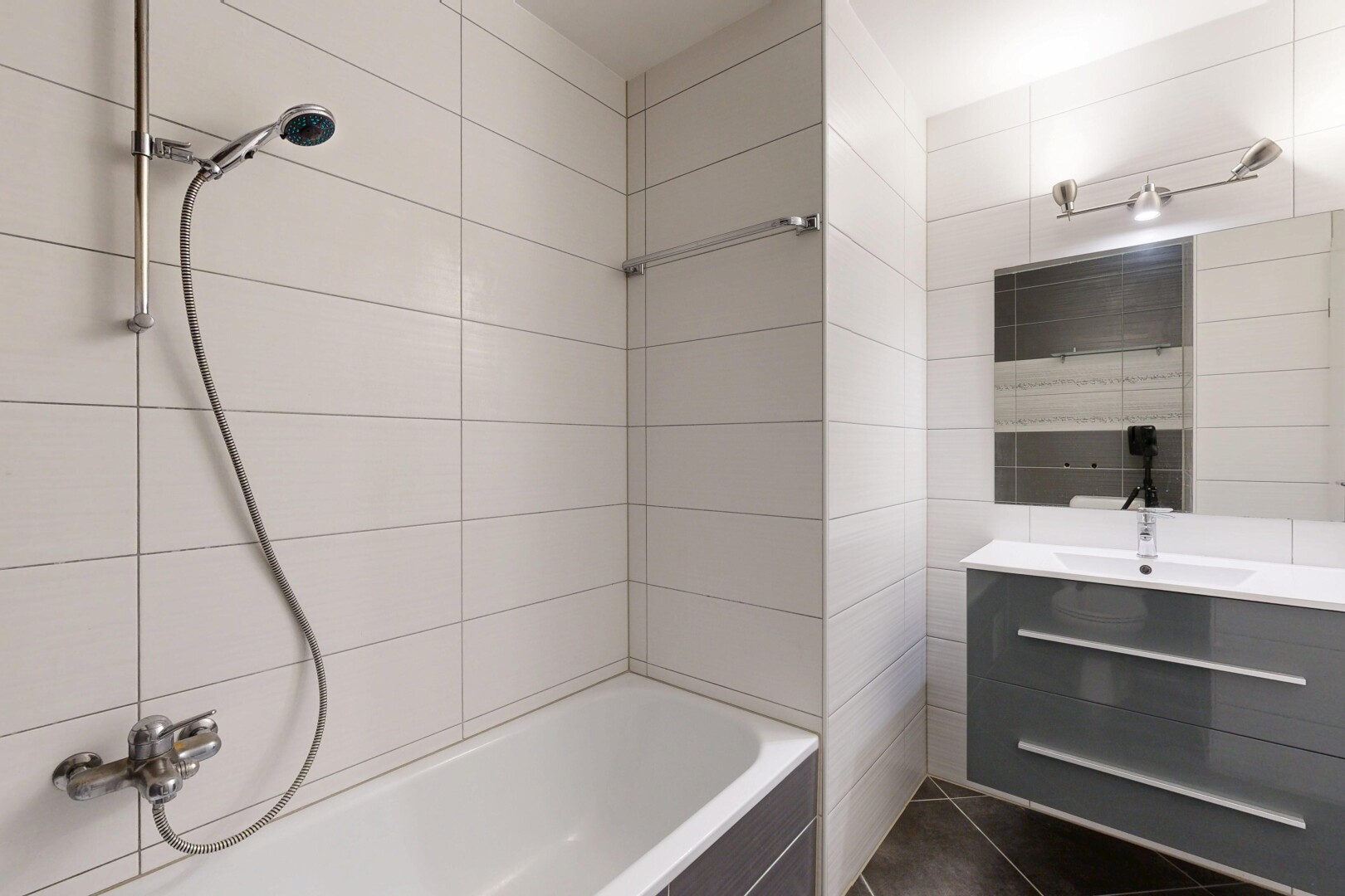 salle de bains avec lavabo (ou coiffeuse selon le contexte), miroir, mur en carrelage, tile wall, et salle de bain complète