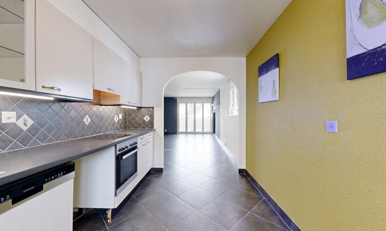 cuisine avec passages en arc, lave-vaisselle, dosseret, backsplash, et armoires blanches