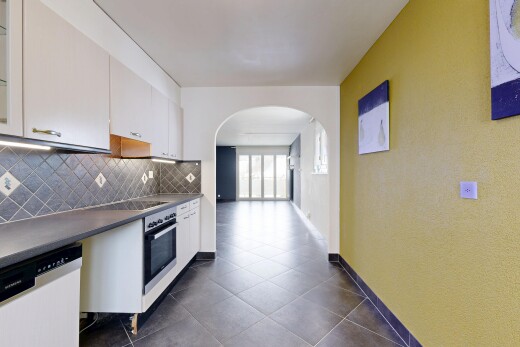 cuisine avec passages en arc, lave-vaisselle, dosseret, backsplash, et armoires blanches