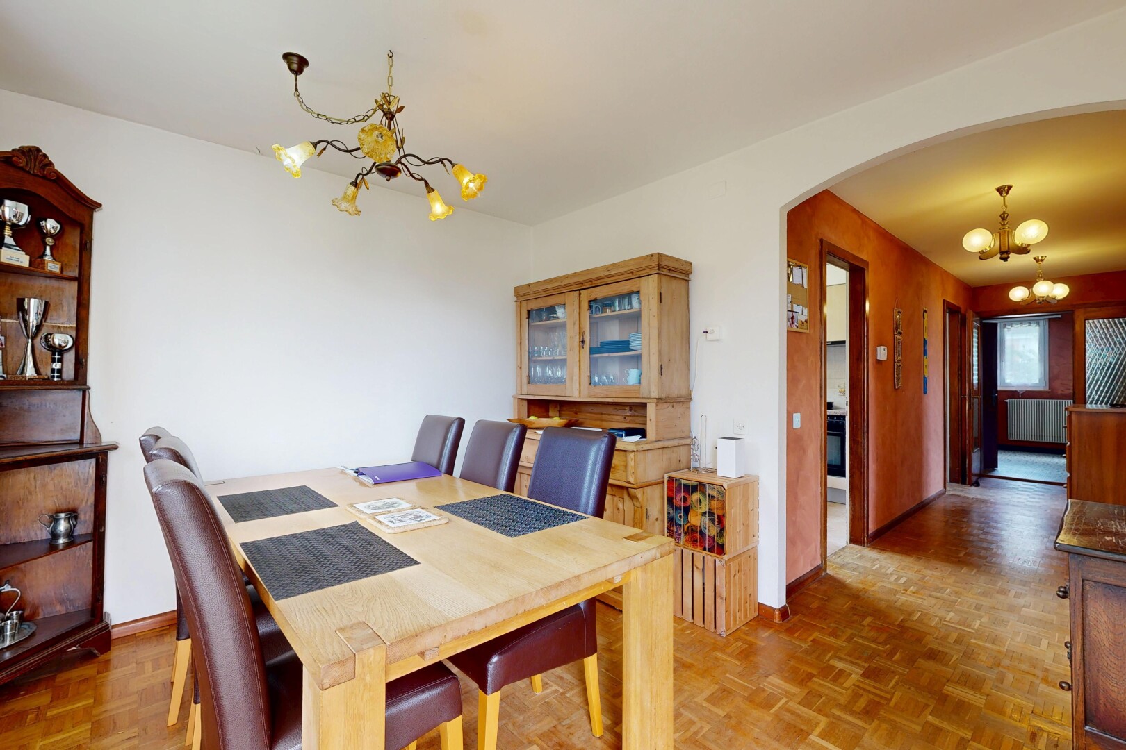 salle à manger avec lustre remarquable, parquet floor, passages en arc, wood finish floor, et sol en finition bois