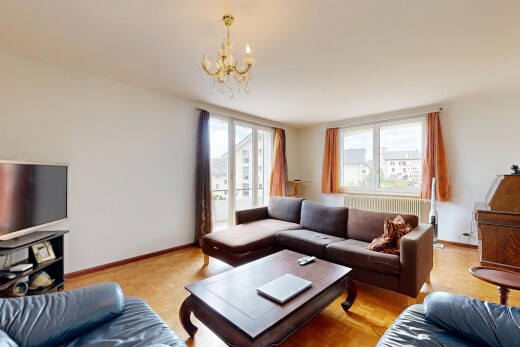 living area with light wood-type flooring, a chandelier, radiator, and healthy amount of natural light