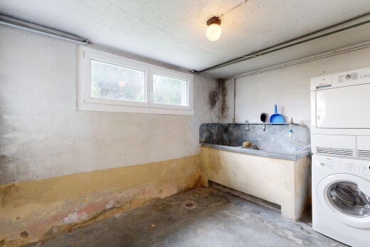 laundry area with stacked washer and clothes dryer and concrete flooring