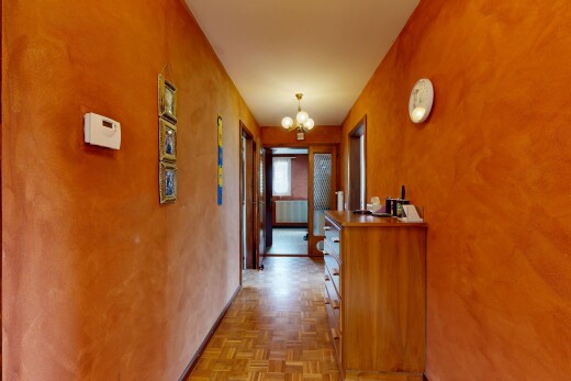 hallway with suspended lighting and parquet flooring