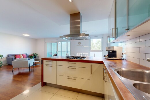 küche mit küchenrückwand beim herd, waschbecken, dunstabzugshaube, herd, und natürliches licht