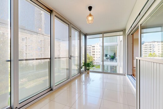 leerer raum mit bodendeckenfenster, fliesenboden, natürliches licht, wintergarten, und stadtblick