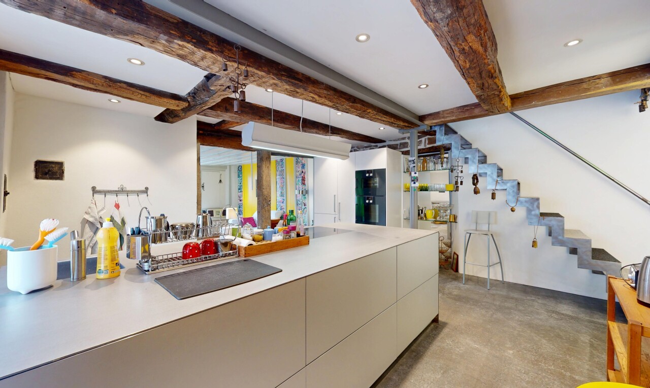 küche mit betonboden, einbauleuchten, schränke mit flachen paneelen, und balkendecke