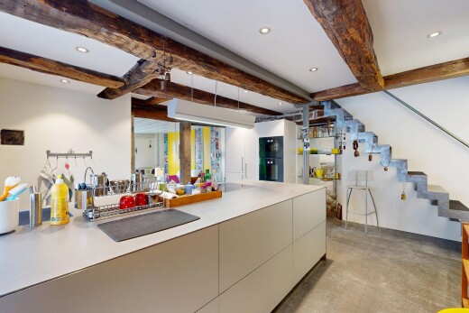 küche mit betonboden, einbauleuchten, schränke mit flachen paneelen, und balkendecke