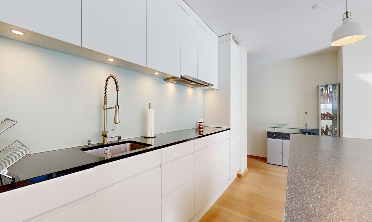 cuisine avec plans de travail, dark countertops, armoires blanches, white cabinets, et sol en finition bois