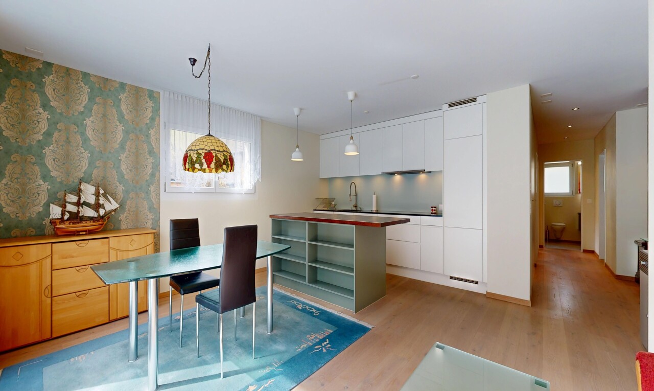cuisine avec dark countertops, inside property, sol en finition bois, wood finish floor, et armoires blanches