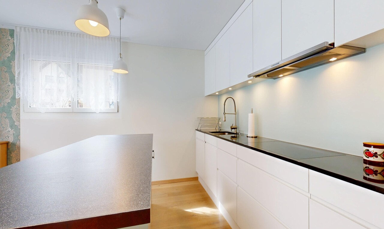 cuisine avec armoires blanches, white cabinets, sol en finition bois, wood finish floor, et éclairage suspendu