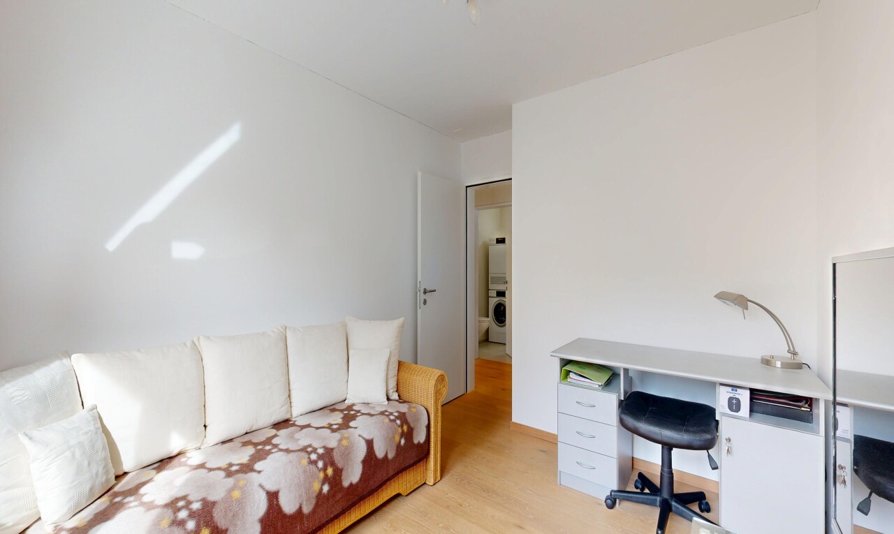salon avec espace bureau, cloison sèche, drywall, sol en finition bois, et wood finish floor