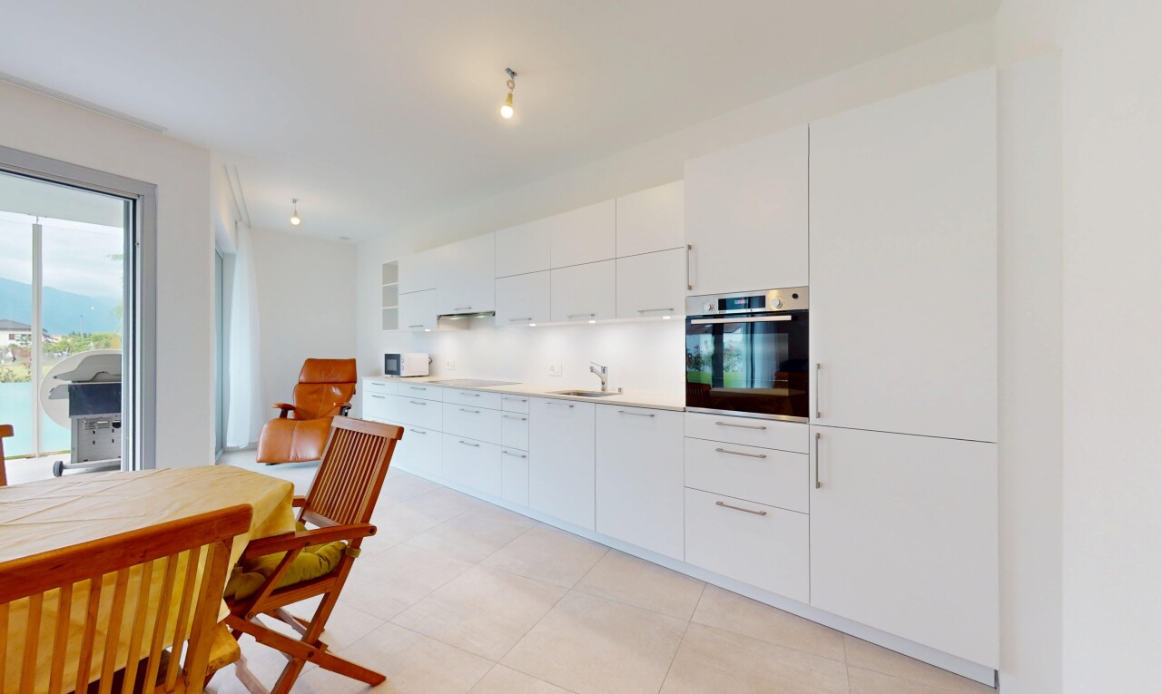 küche mit ofen, waschbecken, inside property, weiße schränke, und natürliches licht