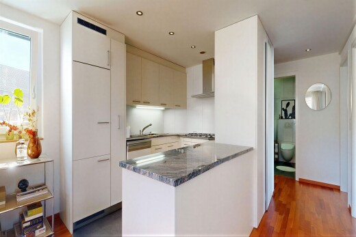 cuisine avec dark countertops, hotte, lumière naturelle, natural light, et sol en finition bois