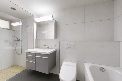 full bath with tile walls, tiled shower, vanity, and tile patterned flooring