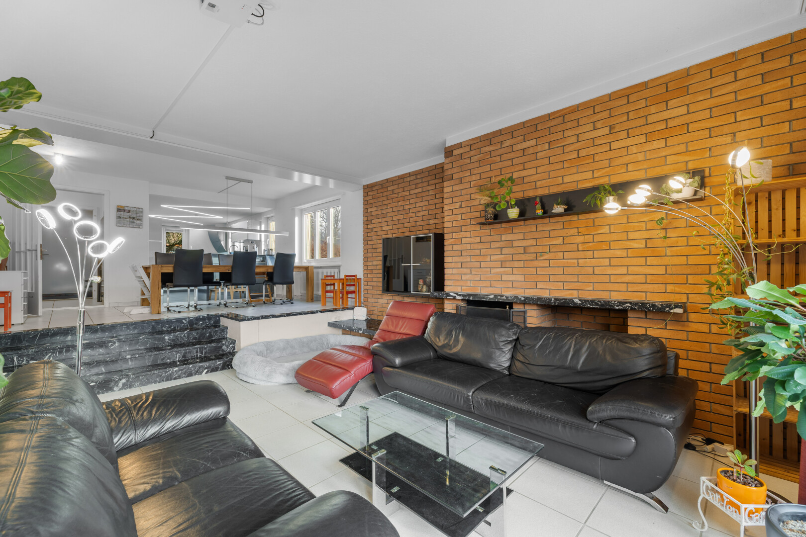 living / dining room featuring brick wall and ornamental molding