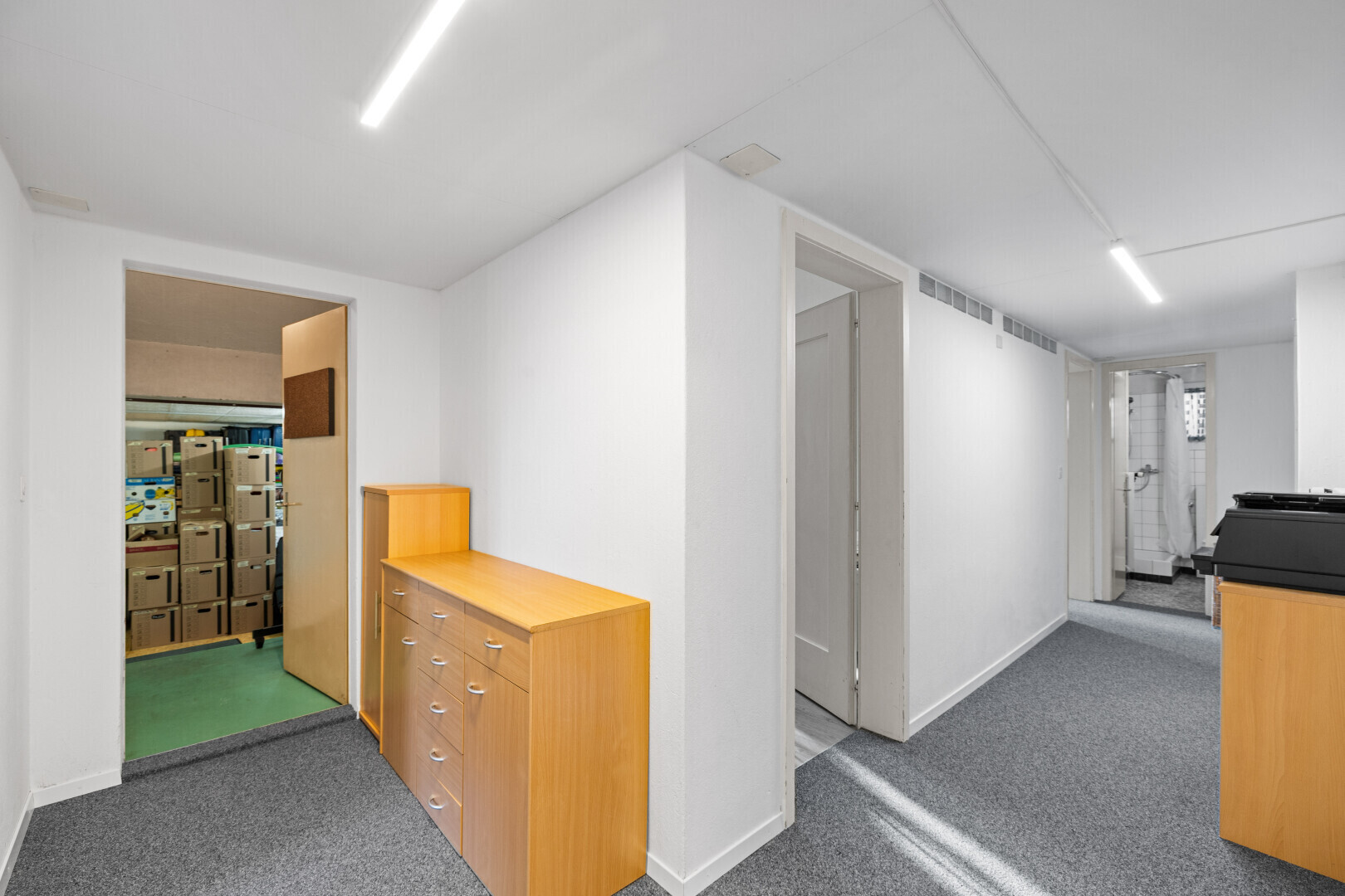 corridor featuring dark colored carpet and baseboards