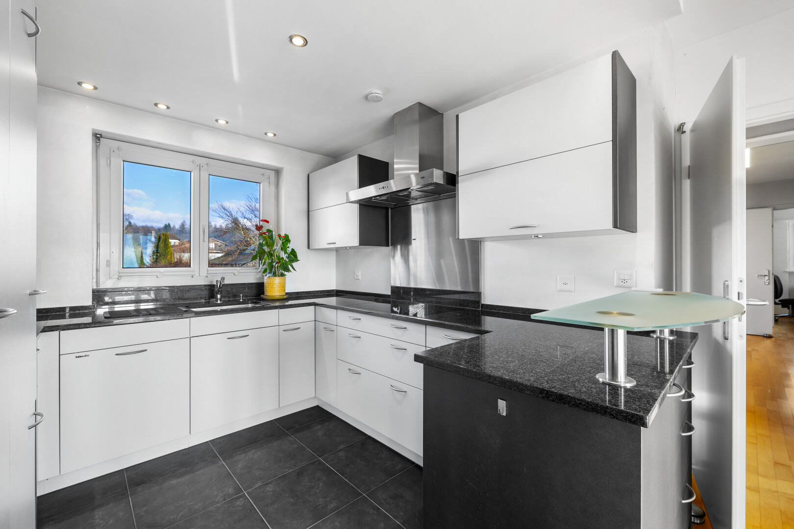 kitchen featuring white cabinets, a peninsula, dark stone counters, and modern cabinets