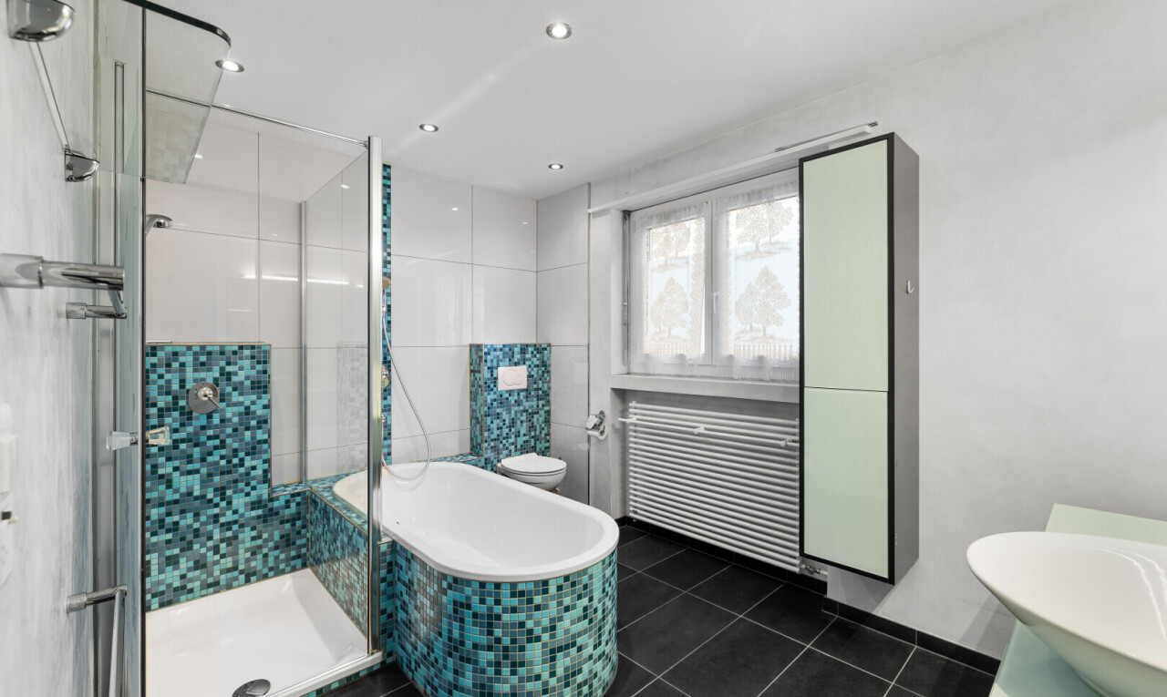salle de bains avec douche, salle de bain complète, radiateur, lavabo (ou coiffeuse selon le contexte), et bain