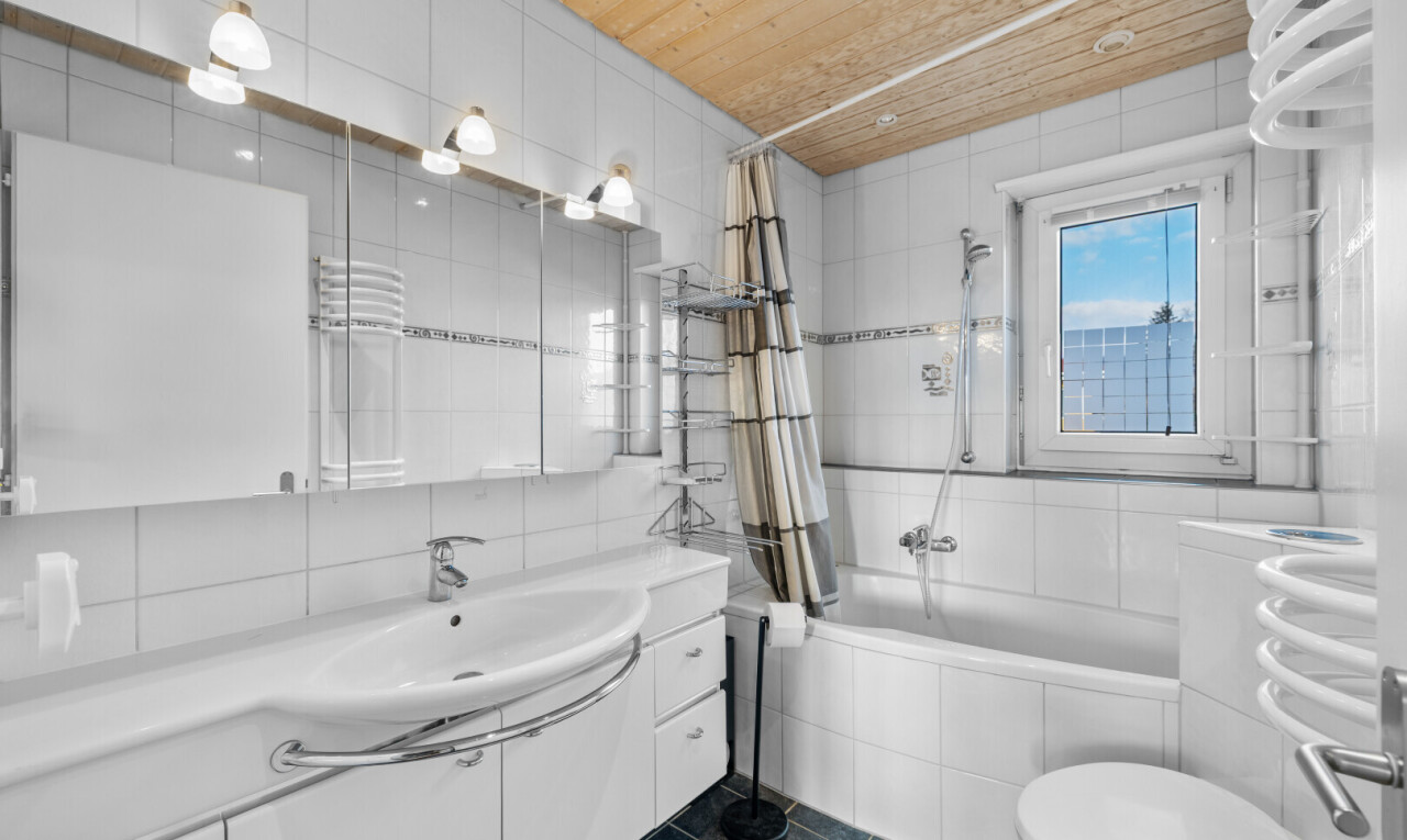 salle de bains avec douche-bain combinés, dark floor, salle de bain complète, tile wall, et mur en carrelage