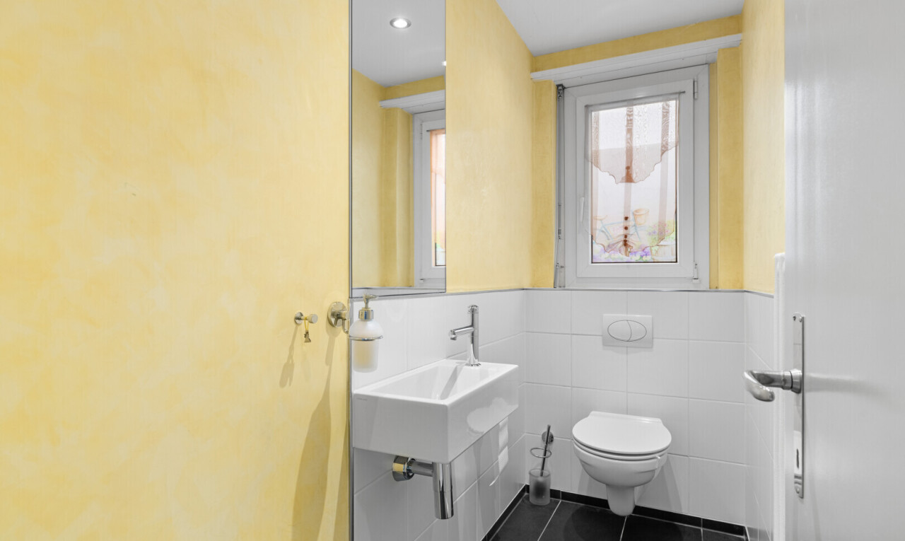 half bathroom featuring dark tile patterned flooring and tile walls
