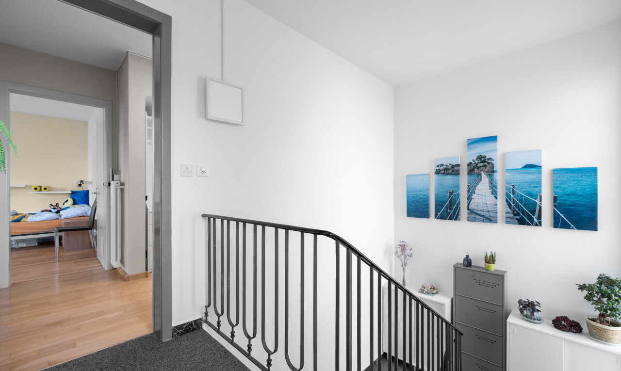 hall with carpet and an upstairs landing