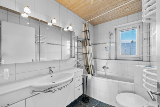 bathroom with tiled shower / bath, tile walls, vanity, a towel warmer, and wooden ceiling