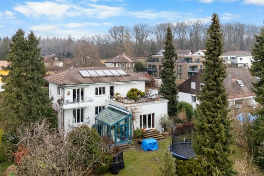view of home with a trampoline, roof mounted solar panels, stucco siding, french doors, and view of scattered trees