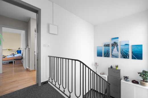 hall with carpet and an upstairs landing