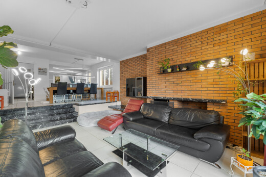 living / dining room featuring brick wall and ornamental molding