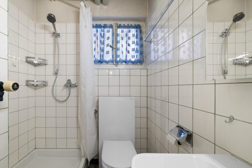 bathroom with a tile shower and tile walls