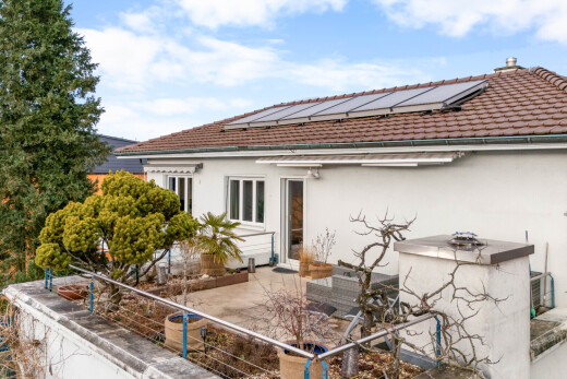 outdoor house with roof mounted solar panels, stucco siding, a tiled roof, a patio area, and outdoor dining space