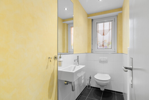 half bathroom featuring dark tile patterned flooring and tile walls