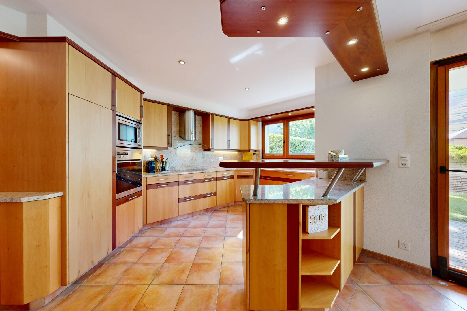 kitchen with backsplash, light tile patterned floors, stainless steel appliances, light stone counters, and exhaust hood
