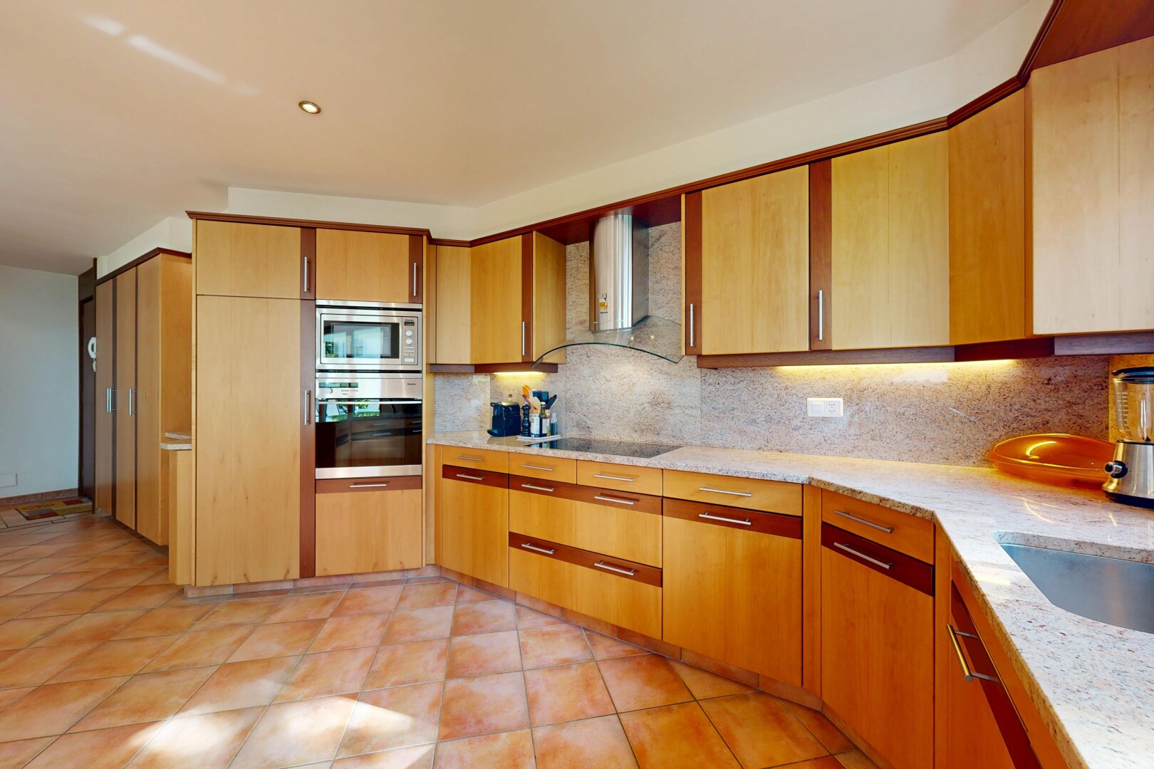 kitchen featuring backsplash, stainless steel appliances, light stone countertops, and light tile patterned floors