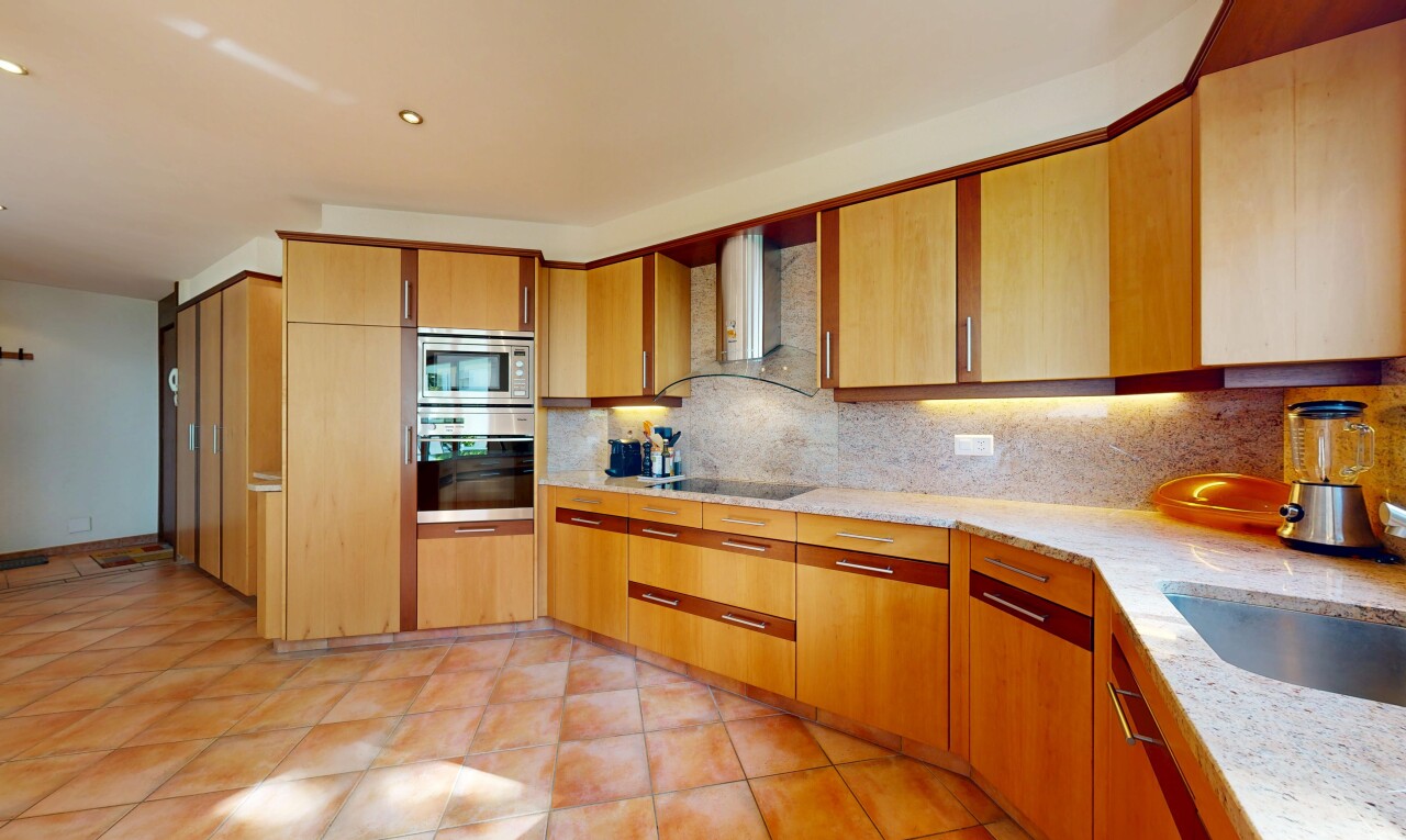kitchen featuring backsplash, stainless steel appliances, light stone countertops, and light tile patterned floors