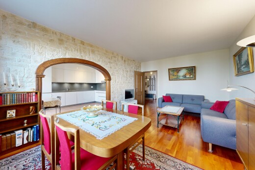 wohn- / esszimmer mit wood finish floor, holzfußboden, inside property, gewölbte gehwege, und fernseher