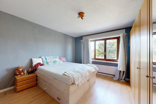 zimmer / schlafzimmer mit holzfußboden, wood finish floor, spritzputz decke, textured ceiling, und light floor