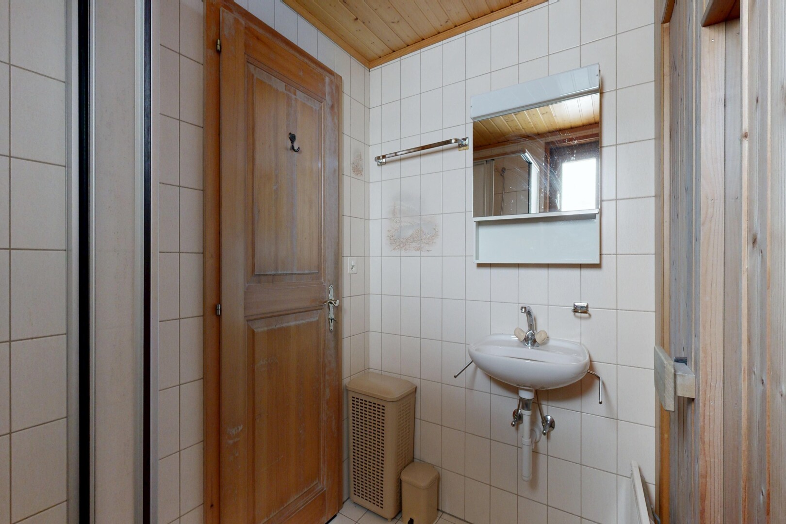 salle de bains avec miroir, mur en carrelage, tile wall, inside property, et évier