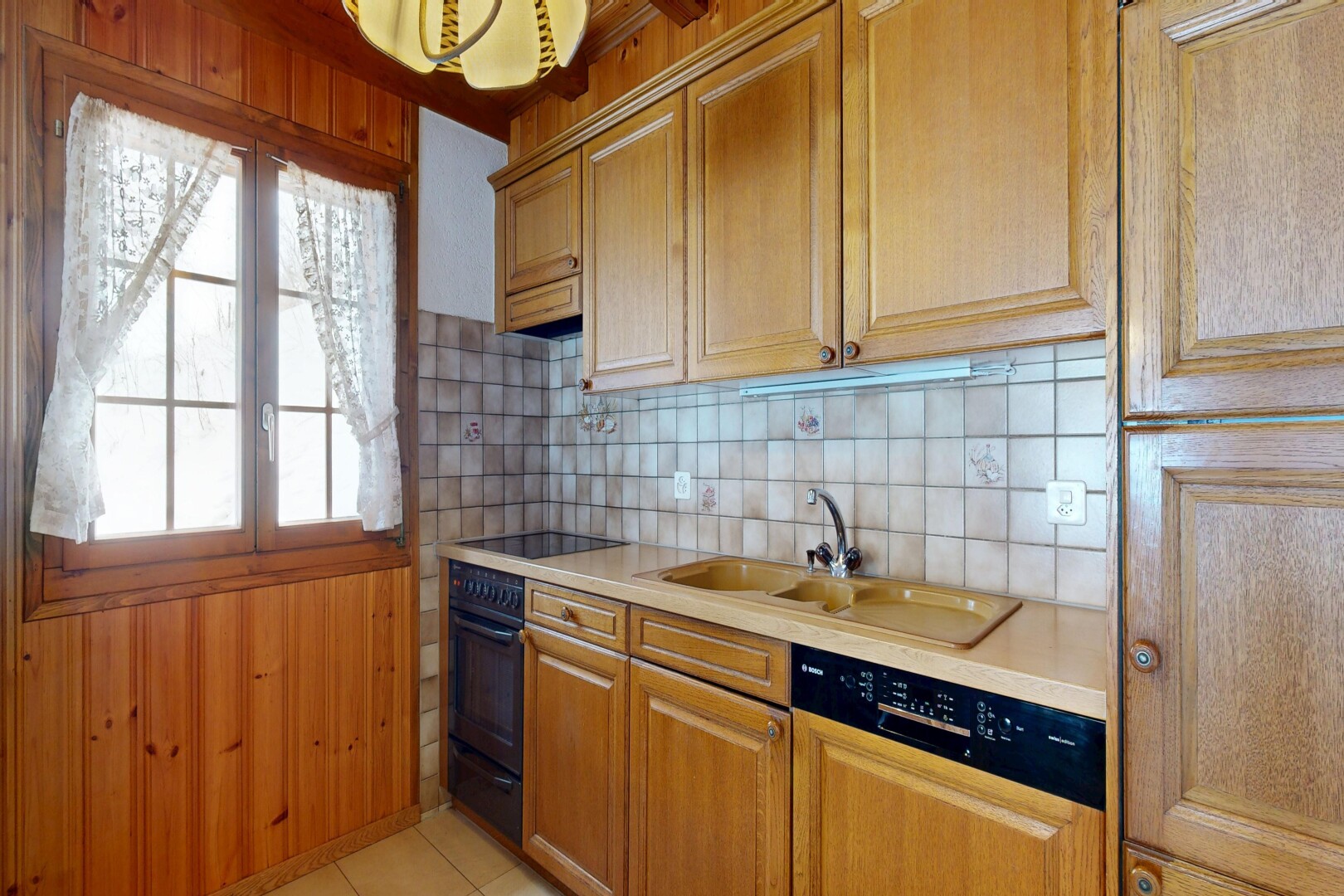 cuisine avec plans de travail, light countertops, dosseret, backsplash, et lumière naturelle