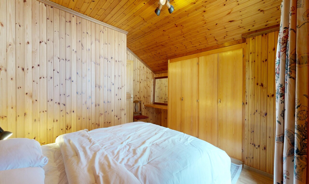 chambre avec wood wall, mur en bois, placard, vaulted ceiling, et plafond voûté