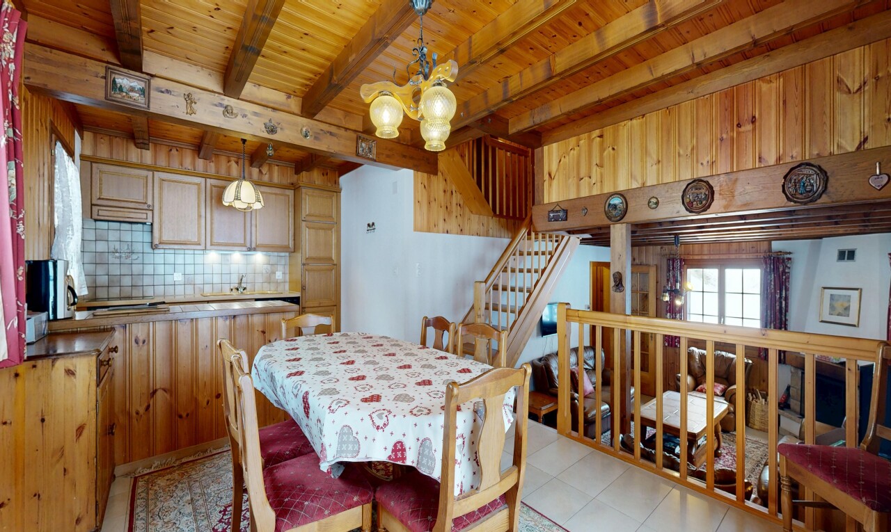 salle à manger avec backsplash, escaliers, inside property, lustre remarquable, et beamed ceiling