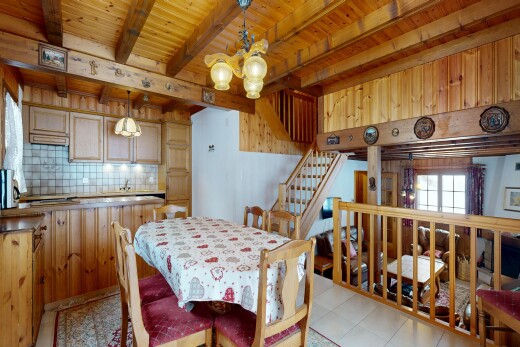 salle à manger avec backsplash, escaliers, inside property, lustre remarquable, et beamed ceiling